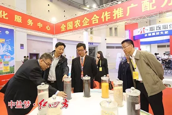 全國農技推廣中心副主任謝建華、全國農技推廣中心土肥處處長辛景樹仔細研究紅四方新型肥料。